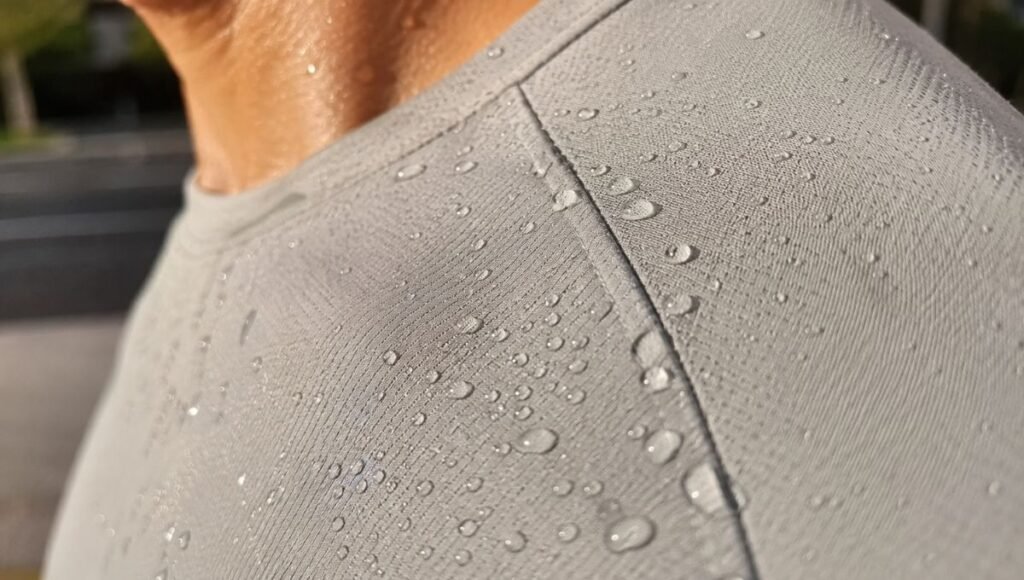 Close-up of sweat beading and evaporating off a moisture wicking running shirt worn by a runner mid-run