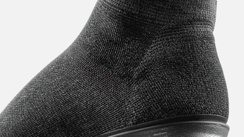A close-up shot of a runner's feet clad in high-performance running shoes, showcasing a pair of elite-grade quarter-length socks featuring a distinct compression support zone at the arch.
