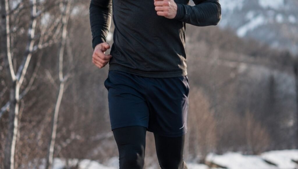 Male runner wearing running shorts over black running tights showing the layered outfit option for cold weather running